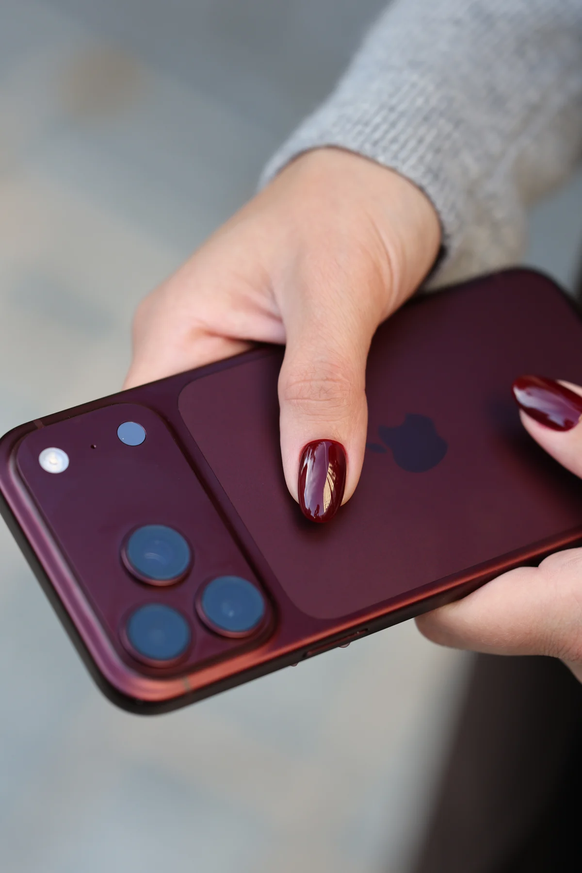 Burgundy nails photographed against a matching phone